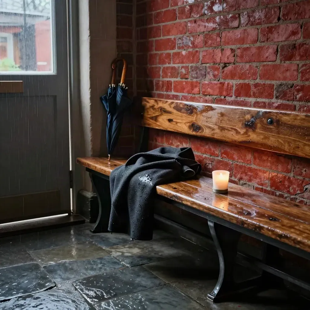 Rain-speckled church foyer bench with folded coat, umbrella stand and votive lamp in storm light.